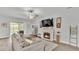 Cozy living room with fireplace, plush sofa, ceiling fan, and sliding glass doors to the patio at 1336 Melrose St, Lake Alfred, FL 33850