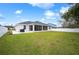 Large backyard with grassy lawn and screened patio at 1427 Magnolia Ln, Auburndale, FL 33823