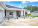 Front porch with stone accents, columns, and small table and chairs at 1427 Magnolia Ln, Auburndale, FL 33823