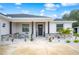 Front porch with stone accents, columns, and small table and chairs at 1427 Magnolia Ln, Auburndale, FL 33823