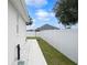 Side yard with walkway, white vinyl fence, and gravel landscaping at 1427 Magnolia Ln, Auburndale, FL 33823