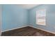 Light blue bedroom with wood-look floors and a window at 155 Kissengen Park Blvd, Bartow, FL 33830