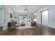 Virtually staged living room featuring a stone wall and sliding glass doors at 155 Kissengen Park Blvd, Bartow, FL 33830