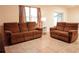 Spacious living room with two brown reclining sofas and large window at 1726 Eagle Hammock Blvd, Eagle Lake, FL 33839