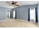 Spacious bedroom with ceiling fan, mirrored closet and neutral carpeting at 1801 Quail Hill Dr, Lakeland, FL 33810