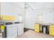 Bright laundry room with yellow cabinets, washer, dryer, and granite countertop at 1801 Quail Hill Dr, Lakeland, FL 33810