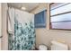 Bathroom with floral shower curtain, toilet, and single window at 2070 Katie Ct, Winter Haven, FL 33884