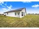 White house exterior with covered patio and grassy backyard at 2200 Mcclellan Rd, Frostproof, FL 33843