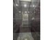 Modern shower with dark marble-look tiles and hexagon floor at 2200 Mcclellan Rd, Frostproof, FL 33843