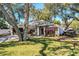 Charming house with mature trees, a well-manicured lawn, and a boat at 2227 Howard West Ave, Winter Haven, FL 33880