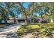 One story home with a paved driveway and large oak trees in the front yard at 2227 Howard West Ave, Winter Haven, FL 33880