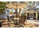 Patio furniture under a striped umbrella in the backyard at 2227 Howard West Ave, Winter Haven, FL 33880