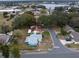 Aerial view showing a light blue house on a tree-lined street near a lake at 2304 Honey Dr, Lakeland, FL 33801