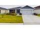 Charming home features a large driveway, an attached two-car garage, and manicured landscaping at 2610 San Marco Way, Winter Haven, FL 33884