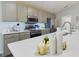 Bright kitchen features stainless appliances, gray cabinets, and white countertops at 2610 San Marco Way, Winter Haven, FL 33884