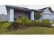 Landscaped front yard includes flowering bushes, trees, and green grass at 2610 San Marco Way, Winter Haven, FL 33884