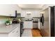 Bright kitchen with white shaker cabinets, stainless steel appliances, and hardwood floors at 2729 Woodland Hills Ave, Lakeland, FL 33803