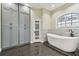 Spa-like bathroom with soaking tub, gray cabinets, and dark tile floors at 2774 Verandah Vue Way, Lakeland, FL 33812