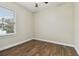 Bright bedroom featuring dark wood-look floors and a window with blinds at 2774 Verandah Vue Way, Lakeland, FL 33812