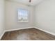 Well-lit bedroom with dark wood-look floors and window blinds at 2774 Verandah Vue Way, Lakeland, FL 33812