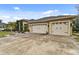 Tan house exterior with three-car garage and landscaped yard at 2774 Verandah Vue Way, Lakeland, FL 33812