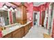 Double vanity bathroom with granite counters, a large shower, and red floral wallpaper at 2961 Sanctuary Cir, Lakeland, FL 33803