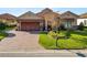 Two-story home with brick paver driveway and landscaped lawn at 2961 Sanctuary Cir, Lakeland, FL 33803