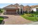 Spanish style home with brick driveway and landscaping at 2961 Sanctuary Cir, Lakeland, FL 33803