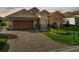 Brick paver driveway leads to a charming two-story home with a large garage at 2961 Sanctuary Cir, Lakeland, FL 33803