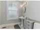 Updated bathroom with pedestal sink, modern fixtures, and large window at 306 Avenue C Ne, Winter Haven, FL 33881