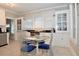 Kitchen with white cabinets, glass table, and blue chairs at 306 Avenue C Ne, Winter Haven, FL 33881