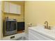 Laundry room with washer, dryer, cabinets, and utility sink at 306 Avenue C Ne, Winter Haven, FL 33881