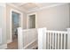 Upstairs hallway with white railings and access to bathroom at 306 Avenue C Ne, Winter Haven, FL 33881