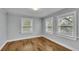 Well-lit bedroom featuring three windows and wood flooring at 3220 Clubhouse Rd, Lakeland, FL 33812