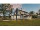 Side view of a charming two-story house with white siding and a spacious lawn at 3220 Clubhouse Rd, Lakeland, FL 33812