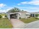 Tan single-story home with carport and landscaping at 3221 Pebble Bend Dr, Lakeland, FL 33810