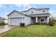 Two-story house with gray siding, attached garage, and landscaped lawn at 4185 Shearwater St, Lakeland, FL 33811