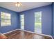 Blue bedroom with hardwood floors and multiple windows at 4225 Shadow Wood Ct, Winter Haven, FL 33880