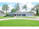 House exterior featuring a landscaped lawn and palm trees at 4225 Shadow Wood Ct, Winter Haven, FL 33880