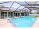 Relaxing screened-in pool with stone patio and sliders to interior at 4225 Shadow Wood Ct, Winter Haven, FL 33880