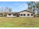 House front view, featuring a beige house with brown accents and a large yard at 4312 Glenview Dr, Lakeland, FL 33810