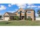 Two-story house with beige exterior, landscaping, and a three-car garage at 4512 Brookshire Pl, Lake Wales, FL 33898