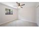 Bright bedroom features neutral carpet, a ceiling fan with light, and a window overlooking the neighborhood at 4718 Valley Hill Ct, Lakeland, FL 33813