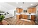 Open kitchen featuring wood cabinets, stainless steel appliances, and wood flooring leading to a living area at 4718 Valley Hill Ct, Lakeland, FL 33813