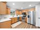 Bright kitchen features stainless steel appliances, wooden cabinetry, white subway tile backsplash, and wood flooring at 4718 Valley Hill Ct, Lakeland, FL 33813