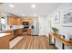 Well-lit kitchen with stainless steel appliances, wood cabinets, tile backsplash, and hardwood floors at 4718 Valley Hill Ct, Lakeland, FL 33813