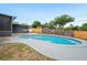 Backyard pool features a concrete deck, screened in porch and surrounding wooden fence, perfect for outdoor retreat at 4718 Valley Hill Ct, Lakeland, FL 33813