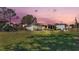 Spacious backyard with patio and playset at sunset at 5125 Pheasant Dr, Mulberry, FL 33860