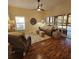 Bright living room with hardwood floors, comfy seating, and sliding glass doors leading to a lanai at 5269 Pebble Beach Blvd, Winter Haven, FL 33884