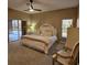 Bedroom featuring a ceiling fan, view of lanai and pool, a white bed frame, and sitting chair at 5269 Pebble Beach Blvd, Winter Haven, FL 33884